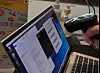 A Grant Thornton Australia IT worker's hand scanning a barcode