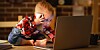 Toddler working with computer and smartphone