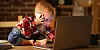 Toddler working with computer and smartphone