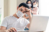 A stresses programmer with a pandemic mask on