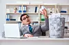 Man in office flippantly throws balls of paper in bin