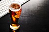 Desk beer - pint at a keyboard. Photo by shutterstock