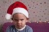 A sad child in a holiday hat