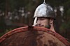 Man in helmet looks uncertain, holds up shield. Photo by Shutterstock