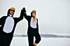 Couple dressed as penguins celebrate in the snow