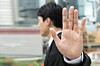 man holds hand up in gesture of rejection