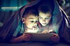 Two kids gather around a tablet