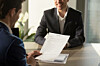 Employer looks at smiling candidate's CV