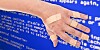 A hand with multiple patches on it in front of a Windows blue screen of death