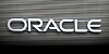 Black and white logo of Oracle on a building with a dark fade