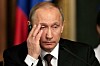 Vladimir Putin rubbing his face with a pained expression