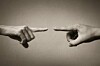 Hands pointing fingers at each other