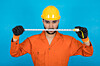 Repairman in orange overalls threateningly wields tape measure