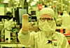 An Intel fab worker holds up Intel's first chip based on its 18A process tech