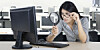Woman peering at something in her office using a magnifying glass