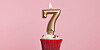 Number 7 gold candle in a cupcake