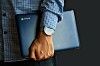 Someone carrying a Chromebook laptop under their arm