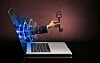 A hand with a key reaching through a computer screen