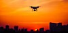 Drone flying over city at sunset
