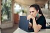 Someone holding their laptop close to them to avoid revealing any secrets