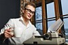 man with old-fashioned typewriter in office