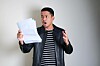man looks shocked reading pages