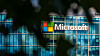 Microsoft logo on a building almost hidden by trees