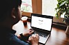 man opens his laptop to Google search page