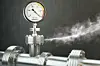 Gas or steam leaking from an industrial pressure gauge