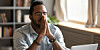 twentysomething man shows signs of huge relief, clasps hands together and closes eyes