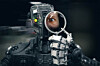 Robot looks into magnifying glass, human eye displayed. Photo by Shutterstock