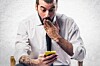 Man looks at his mobile - mildly surprised or shocked about something. Photo by shutterstock
