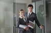 Two sales or business people at the door to an office, walking in