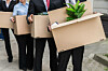 employees leave with cardboard boxes