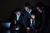 group of people in suits look at laptop screens