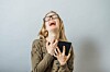 Woman wails in despair while clutching a tablet.