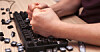 Someone smashing keys off a computer keyboard with their fists