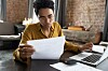 Someone doing their taxes at their desk in a bare-brick office