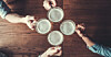 Overhead view of people holding pints of beer in a bar
