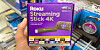 Someone holding a retail package of a Roku streaming stick