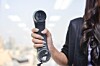 Woman holds up PBX phone in office. Pic by Shutterstock