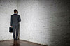 Businessman stands in a corner