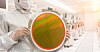 Someone holding a silicon wafer in a chip factory