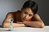 Someone looking sad and depressed looking at a full hourglass