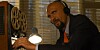 spy in a suit and tie with headphones  listens to audio recorded by bug on a giant tape player...