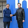 Elon Musk and Intel CEO Lip Bu Tan shake hands outside what appears to be the chipmaker's Arizona fab