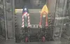 Two decorated bottle rockets on stands behind glass in an indoor science exhibit.
