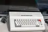 Tandy Color Computer 2 resting on a table with cables nearby