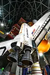 Space shuttle displayed vertically inside a domed exhibition hall.