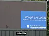 A digital billboard shows a blue Windows backup prompt with Alight Media branding below.